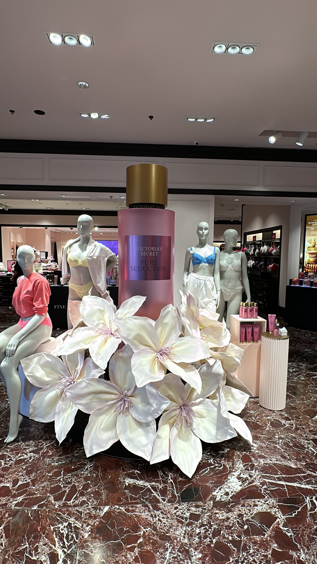 Victoria's Secret vitrininde dev parfüm maketi ve büyük boy sedefli strafor çiçek düzenlemesi